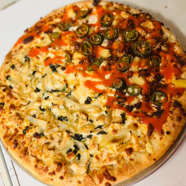 Bonilla's Pizza with two halves: one with onions and black olives, the other with pineapple and jalapeños.